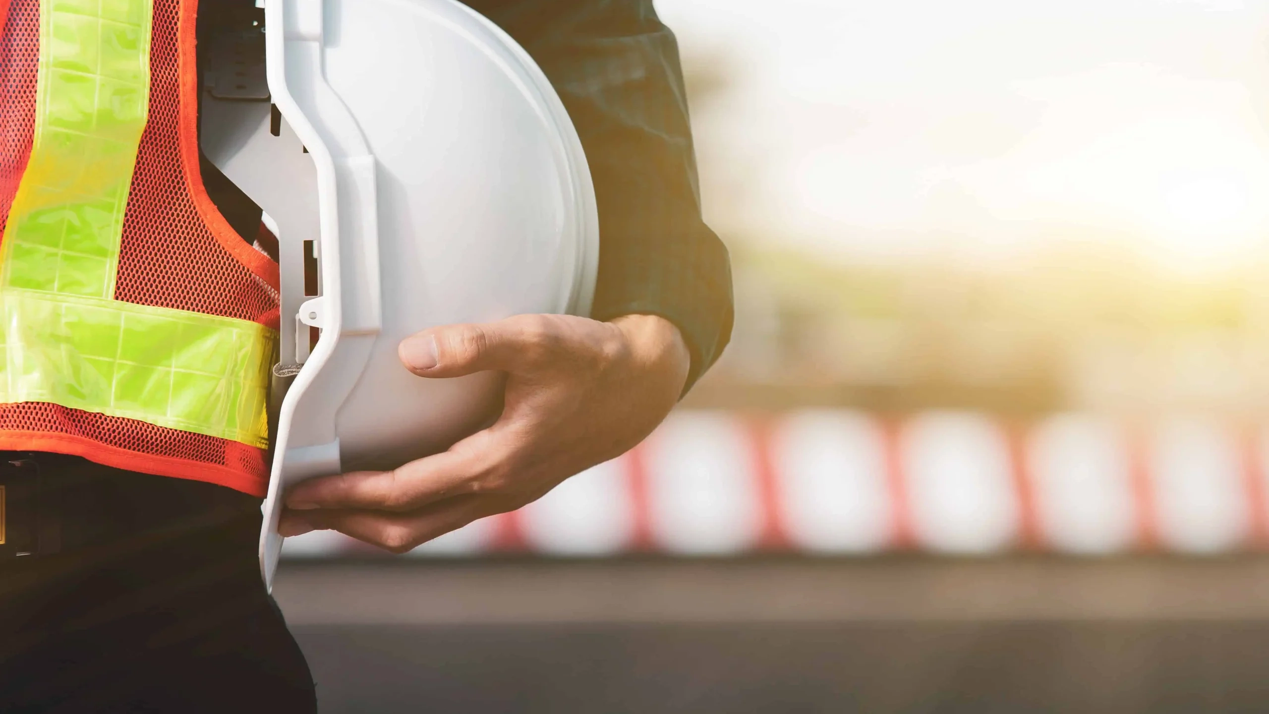 Construction worker holding white hardhat